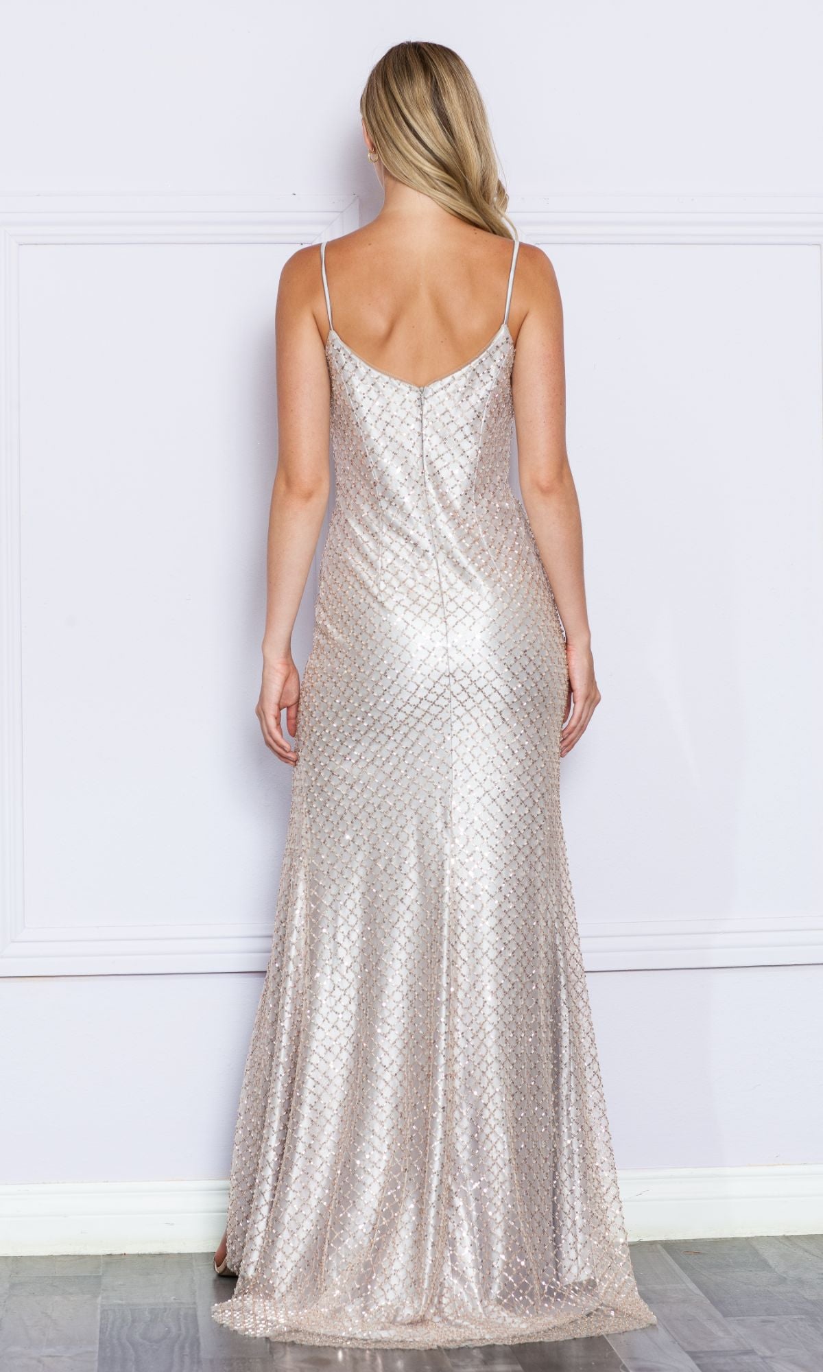 A woman faces away, wearing the Sequin-Net Long Prom Dress with Side Slit 9288—a sleeveless, floor-length gown with thin straps and a shimmering geometric pattern.